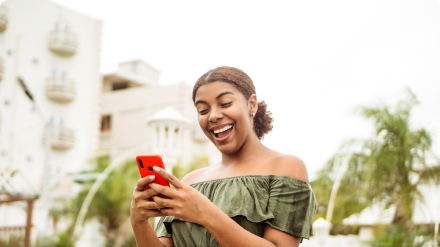 Vrouw die vrolijk naar het beeld van haar mobiele telefoon kijkt